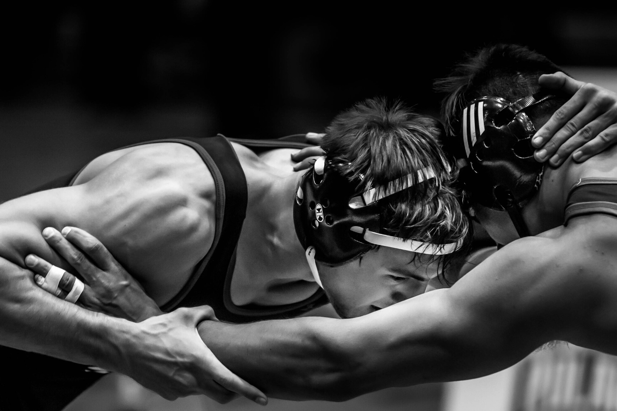 Two wrestlers locked in a head tie on the mat